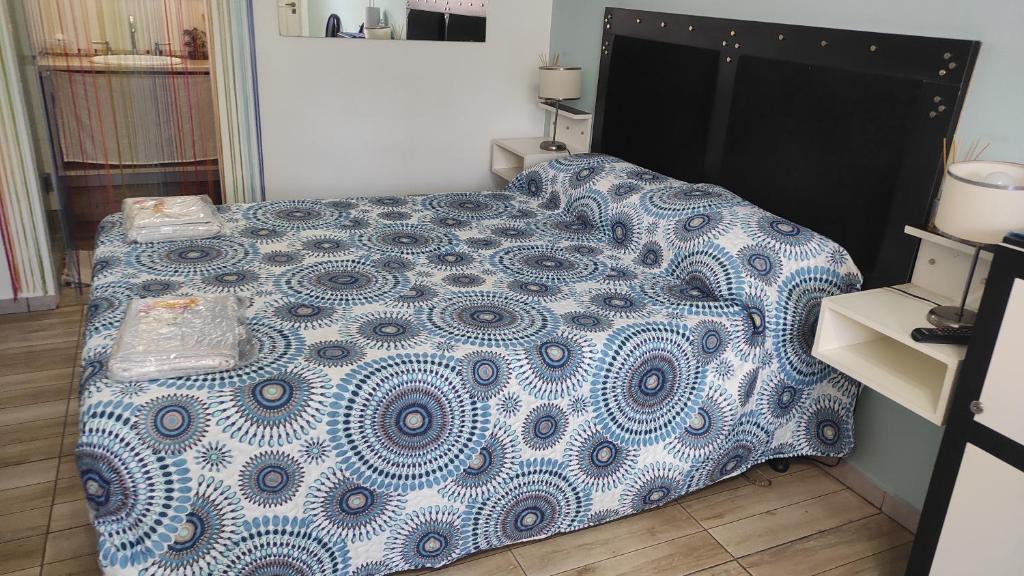a bed with a blue and white comforter in a bedroom at 2 Nuestro Lugar a 15 minutos del aeropuerto opcional tranfer in Ezeiza