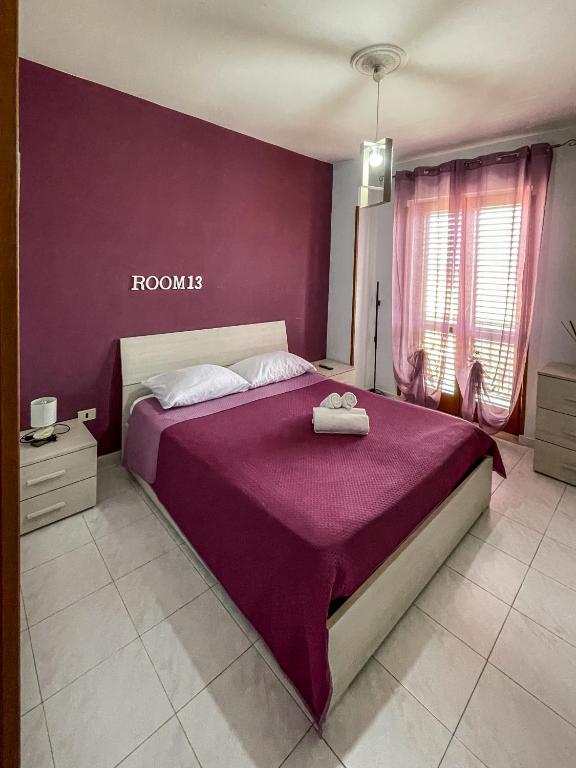 um quarto com uma cama roxa com toalhas em La Piazzetta Fittacamere em Torella deʼ Lombardi