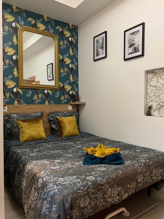 une chambre avec un lit avec un miroir au mur dans l'établissement Paris Golden Studio, à Paris