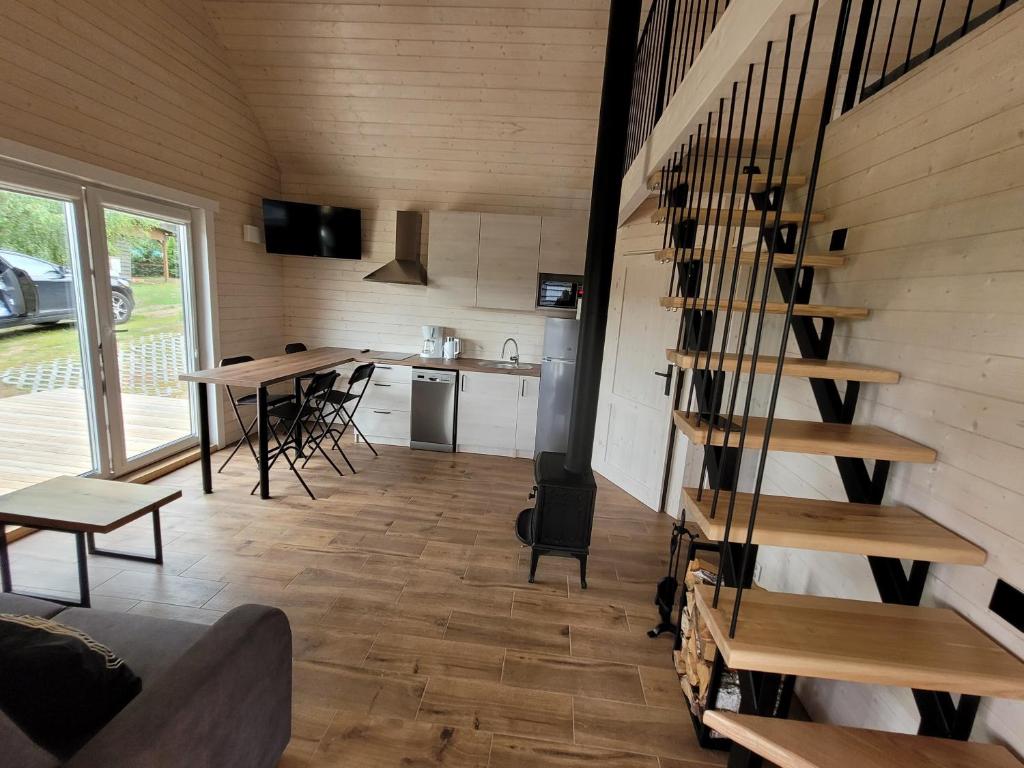 a living room with a spiral staircase in a tiny house at APANÓWKA domki z balią jacuzzi sauna in Trzebiechowo