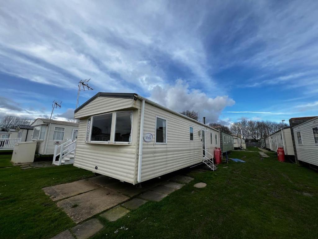 una casita blanca sentada en un patio en Lovely 8 Berth Caravan At Highfield Grange In Essex Ref 26213o, en Clacton-on-Sea