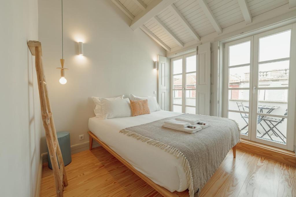 ポルトにあるDeluxe Duplex by Hostyの白いベッドルーム(大型ベッド1台、窓付)