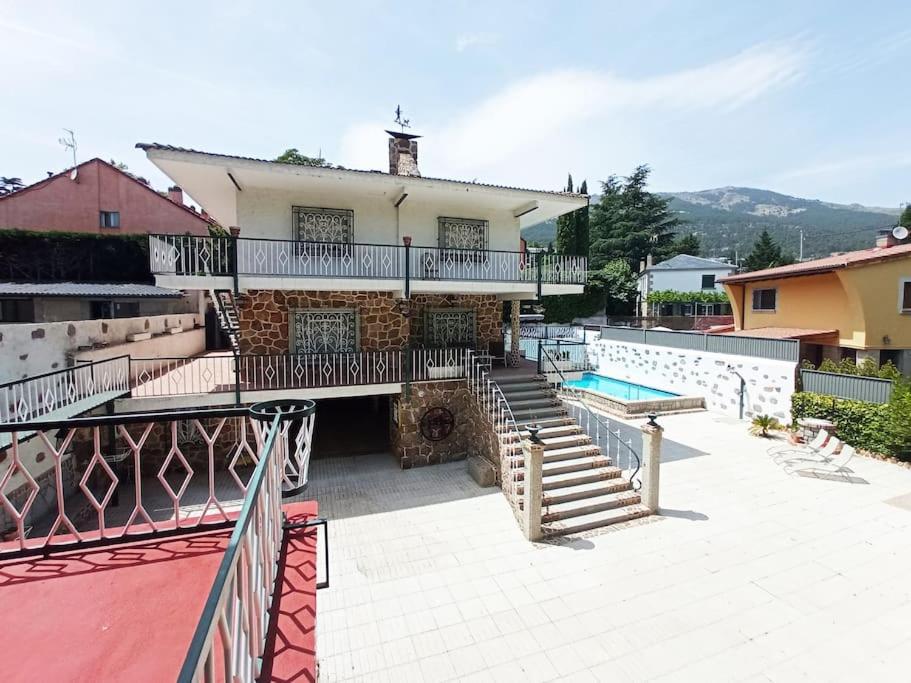 ein Haus mit einer Treppe und einem Pool in der Unterkunft SUYOLUCE, su chalet en la Sierra in El Escorial