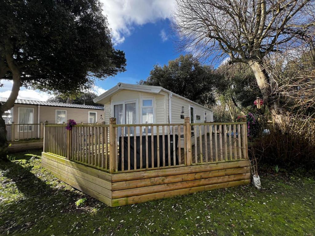 a wooden fence in front of a house at Stunning Caravan With Decking At Azure Seas In Suffolk Ref 32055az in Lowestoft