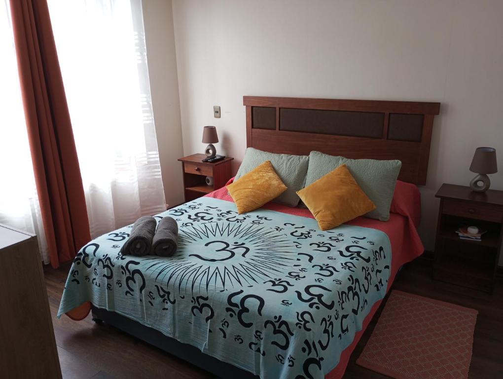 Schlafzimmer mit einem Bett mit einer schwarzen und weißen Bettdecke in der Unterkunft Apartamento en Iquique in Iquique