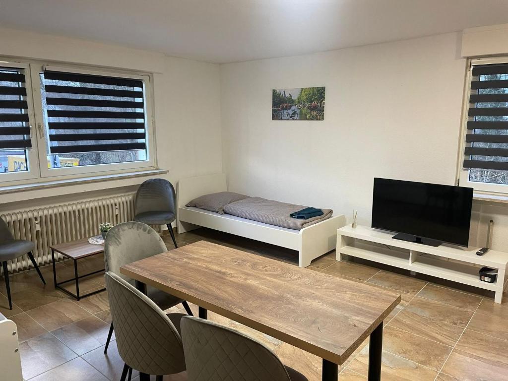 een kamer met een bed, een tafel en een tv bij estrella24 LIVING ROOMS Amsterdam in Castrop-Rauxel