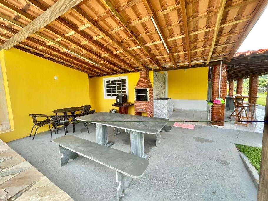 um pátio com uma mesa de piquenique, mesas e cadeiras em Casa de campo com piscina em Socorro