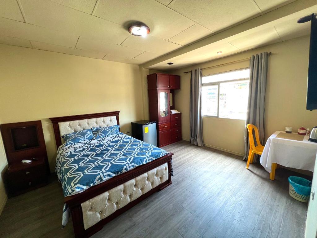 um quarto com uma cama, uma mesa e uma janela em HABITACIÓN CENTRAL em Machala