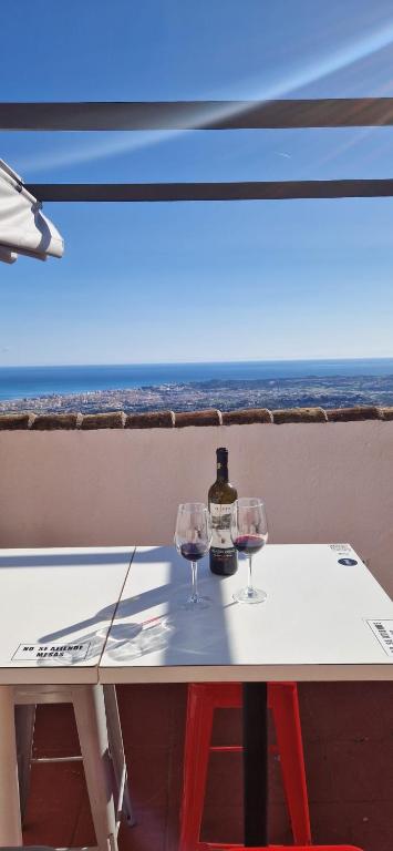 a table with two glasses and a bottle of wine at ALMAFUERTE in Mijas