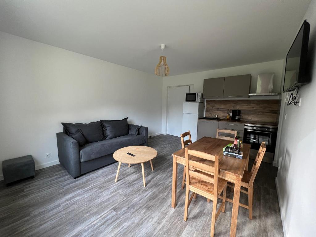 a living room with a table and a couch at Les jardins du Moiron in Le Champ-près-Froges