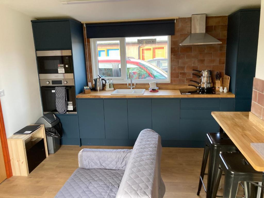 a kitchen with blue cabinets and a sink and a window at G10 Rickardos Holiday Lets in Mablethorpe