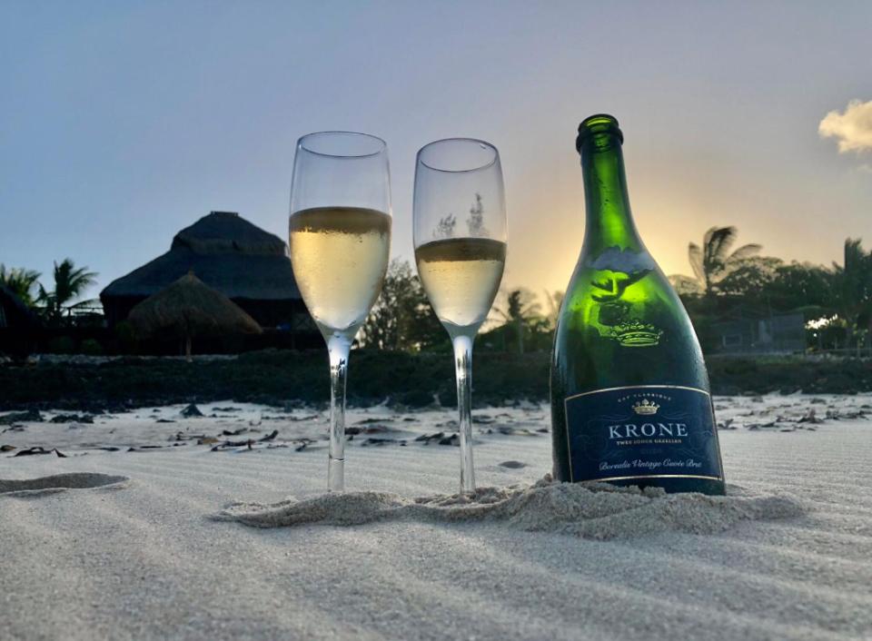 dos copas de vino blanco en la arena de la playa en Casa De Lua - Blue Paradise en Vilanculos