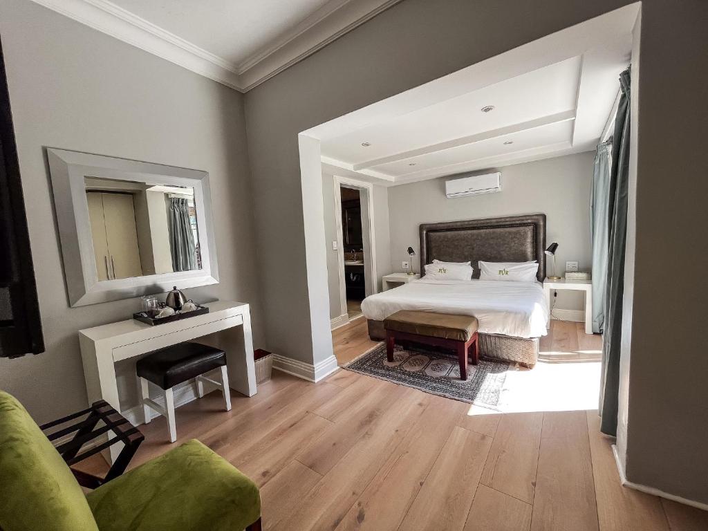a large bedroom with a bed and a mirror at Vetho Villa in Cape Town