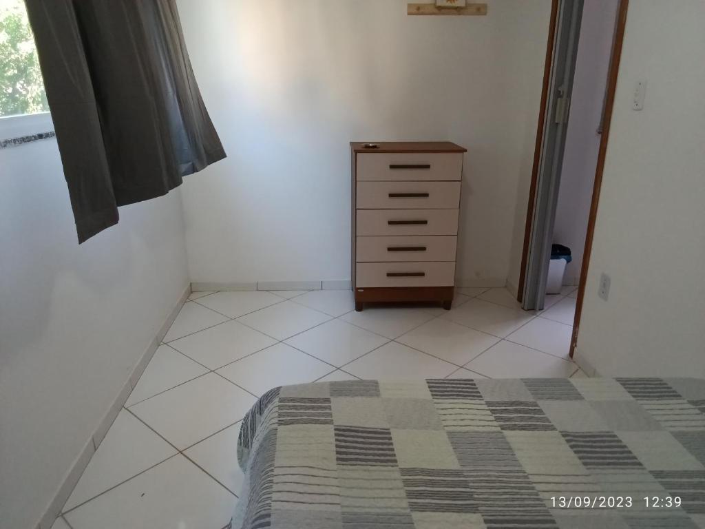 a bedroom with a bed and a dresser at Pé na Areia in Rio de Janeiro