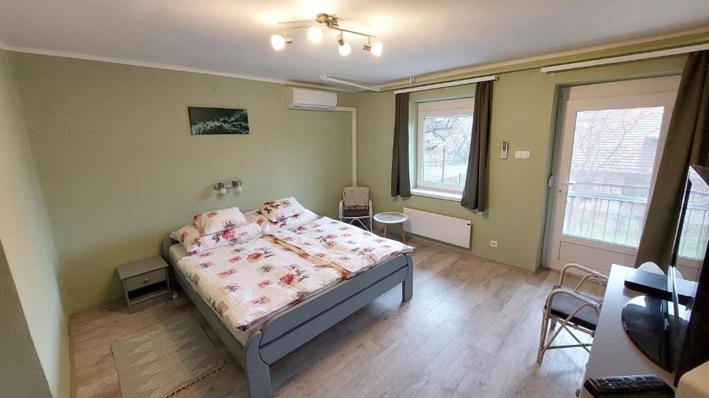 a bedroom with a bed and two windows at miniSZILVA Apartman in Balatonalmádi