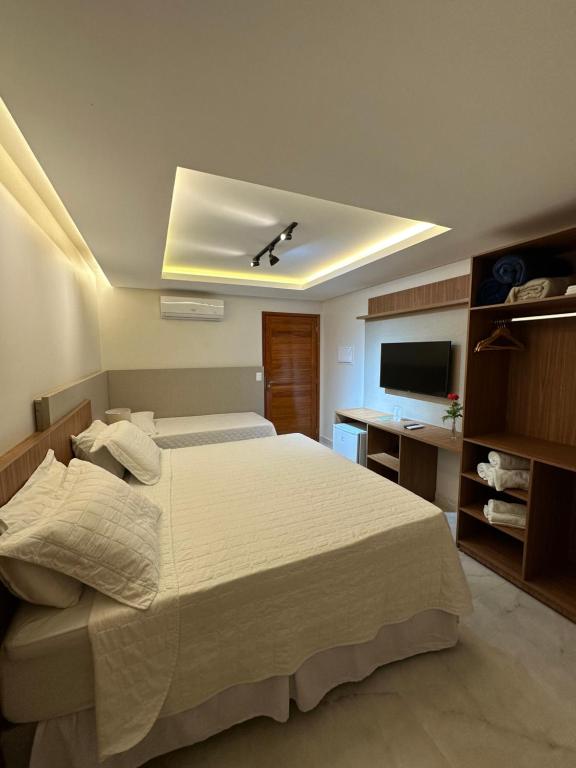 Pousada Baixa Verde في تريونفو: غرفة نوم بسرير كبير وتلفزيون