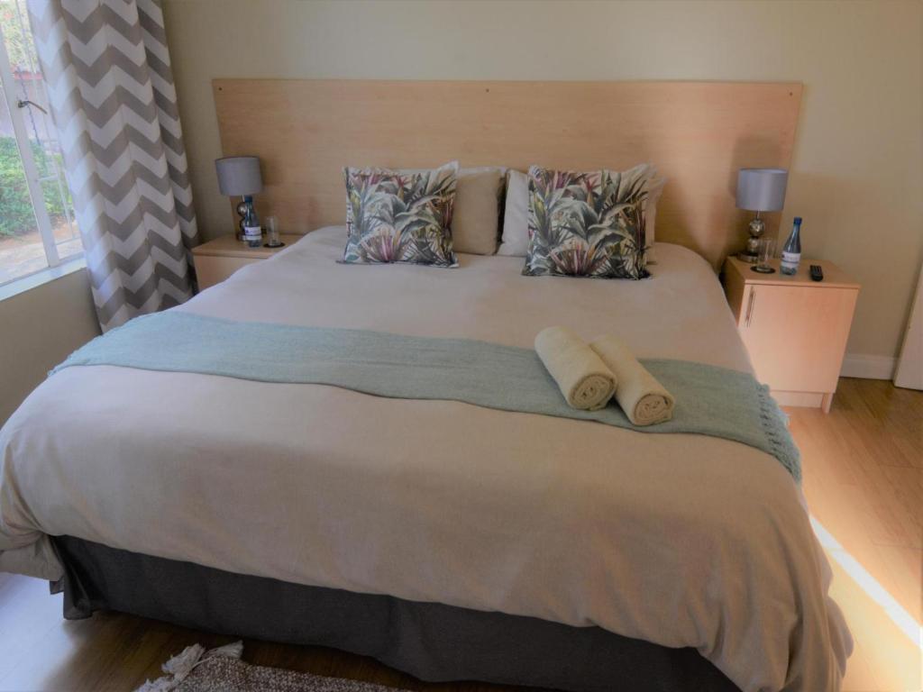 um quarto com uma cama grande e 2 almofadas em Pretoria East Guests em Pretoria