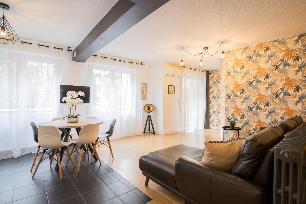 ein Wohnzimmer mit einem Sofa und einem Tisch in der Unterkunft Le Berthelot Saint Roch Appart City Gare in Montpellier