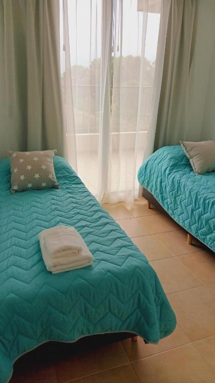 A bed or beds in a room at Condominio Monte Molinos - dpto en Nautico, 2 dormitorios y vista al lago