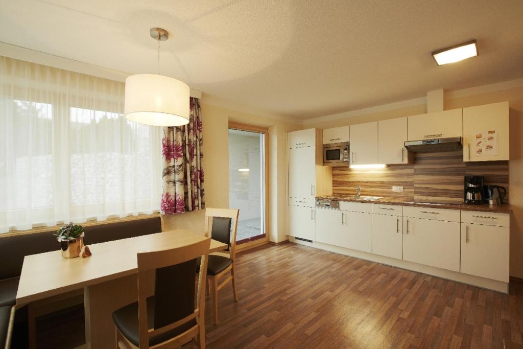 a kitchen and dining room with a table and chairs at Apart Miramunt in Ladis