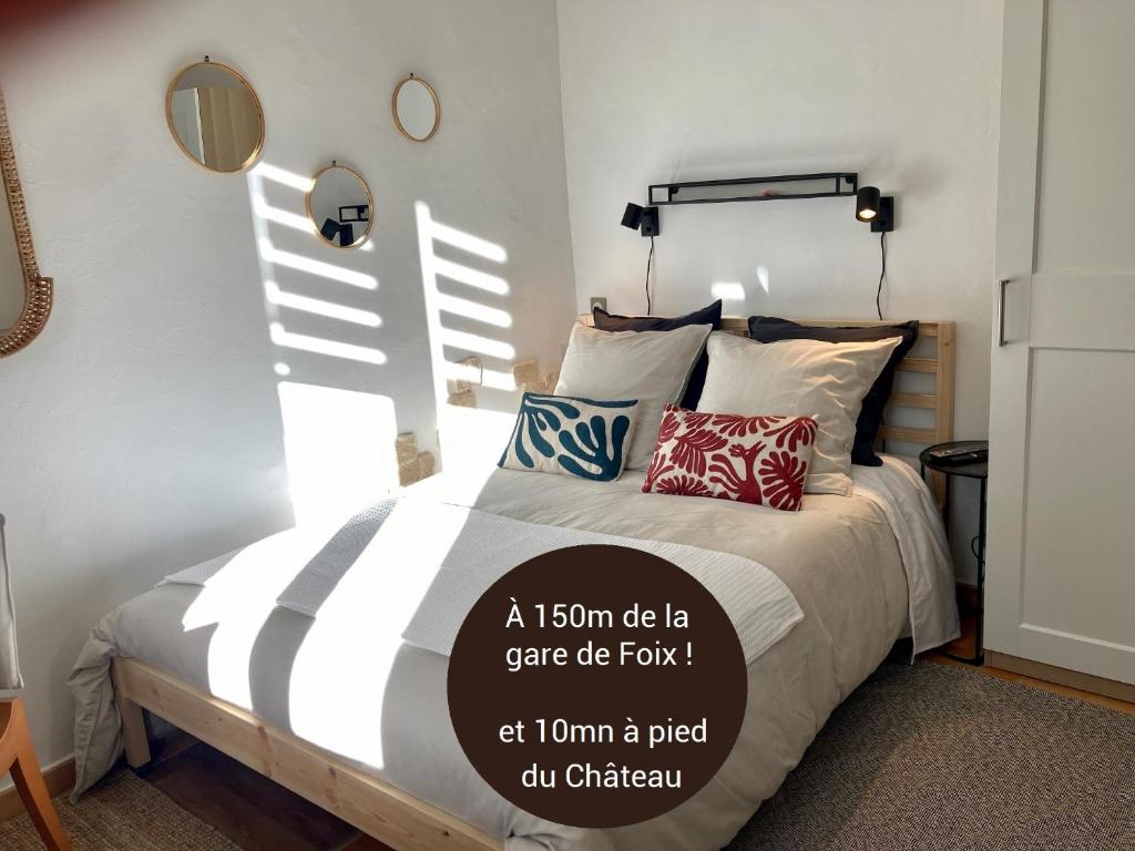um quarto com uma cama com almofadas em Studio Le Terra - Petit déjeuner inclus 1ère nuit - AUX 4 LOGIS em Foix