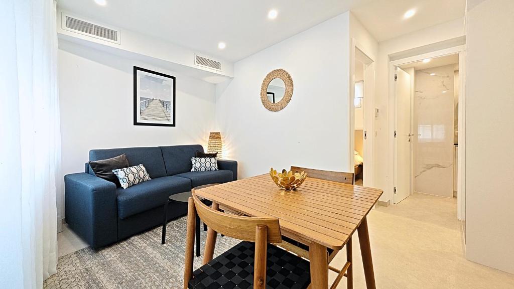 ein Wohnzimmer mit einem blauen Sofa und einem Tisch in der Unterkunft Viva Riviera Brand New Top Floor close Croisette in Cannes