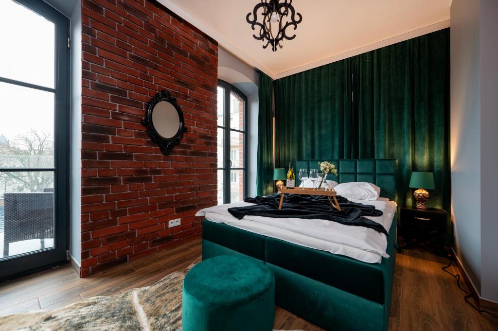 a green bedroom with a brick wall and a bed at Restored Factory Residence - 55m2, Top Location - by Rentujemy in Łódź