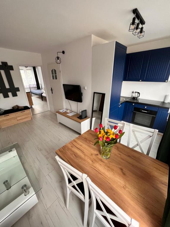 プシェムィシルにあるmieszkanie 2 pokoje, Przemyśl, parterの花が飾られたテーブルのあるリビングルーム