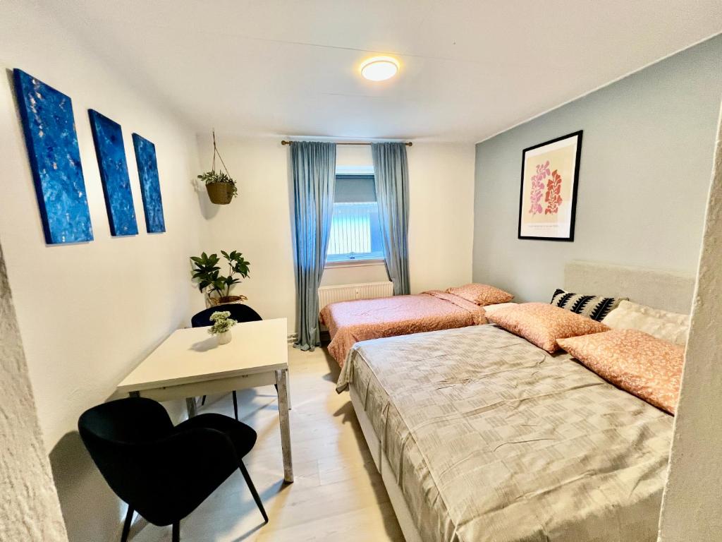 1 dormitorio con 2 camas, mesa y escritorio en 5 minute walk to LEGO house - best location-garden on site-n18, en Billund