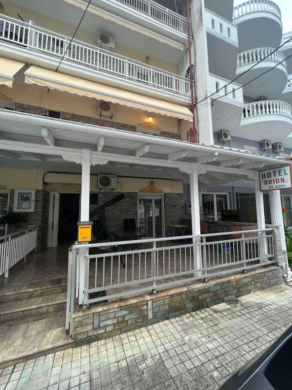 a large building with a white railing in front of it at Hotel Orion Apartment in Katerini