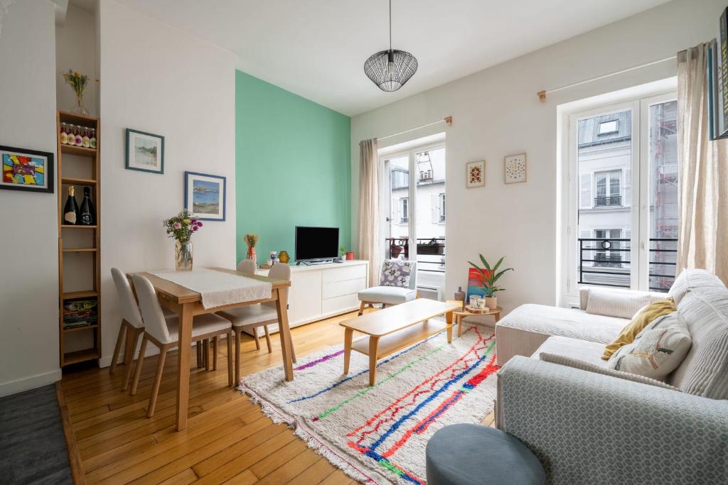 un salon avec une table et un canapé dans l'établissement Appartement L'Epique - Welkeys, à Paris