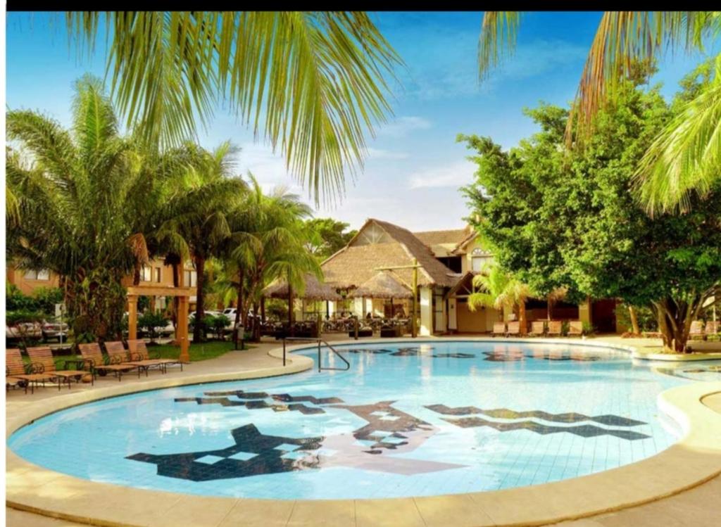 een groot zwembad in een resort met palmbomen bij Departamento 2 dormitorios Hotel/Condominio Buganvillas in Santa Cruz de la Sierra