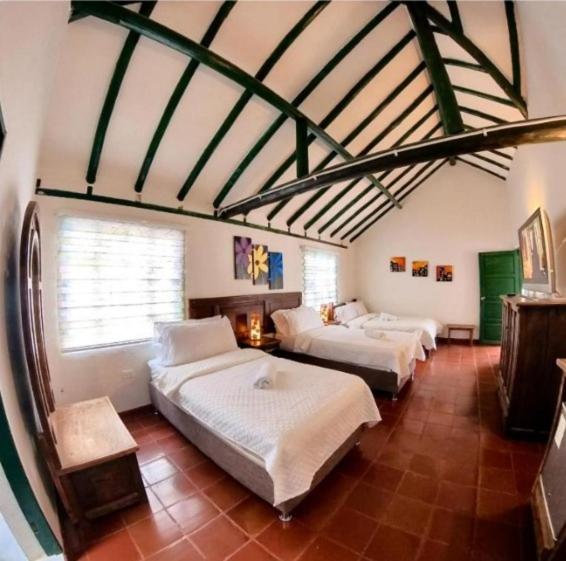 1 Schlafzimmer mit 3 Betten in einem Zimmer in der Unterkunft hotel abahunza in Villa de Leyva