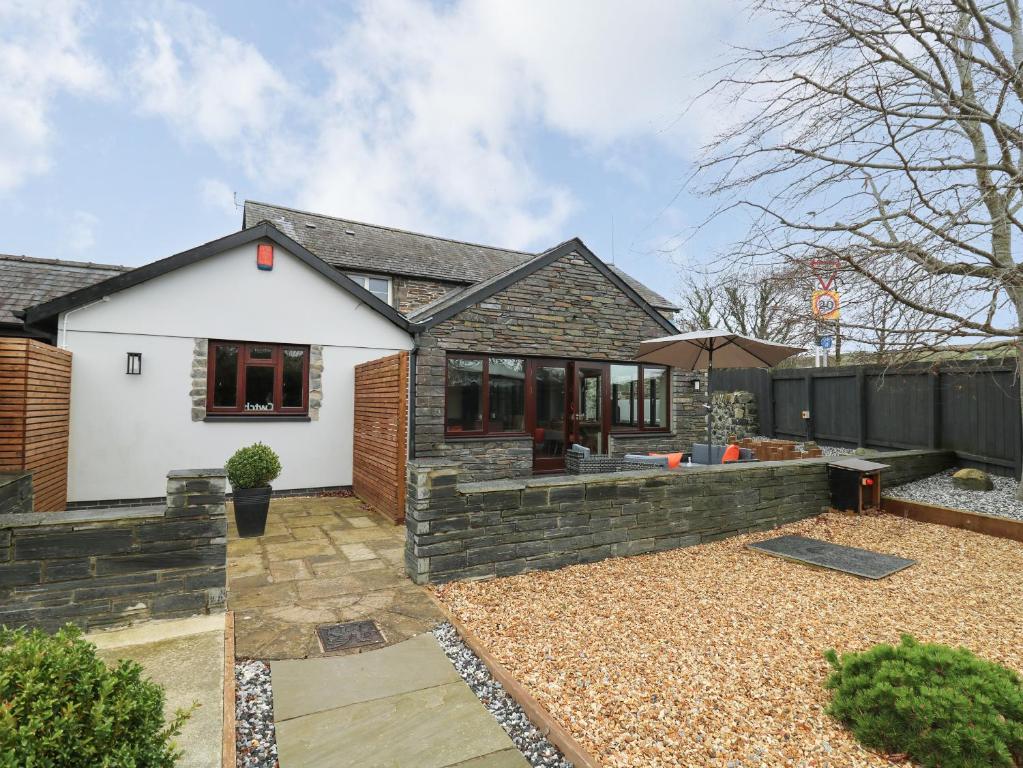 a detached house with a garden and a patio at Dant Y Llew in Bow Street