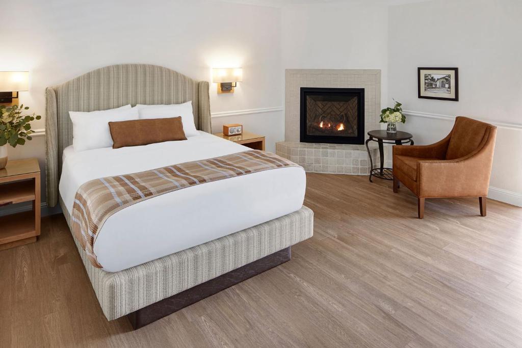 a hotel room with a bed and a fireplace at Coachman's Inn, A Four Sisters Inn in Carmel