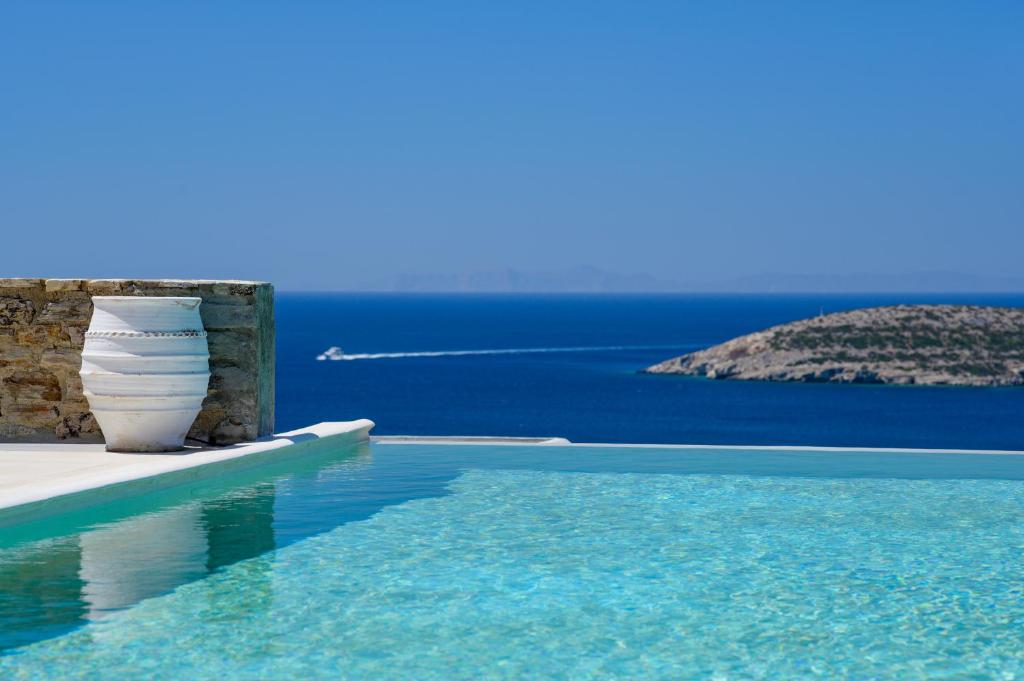 a swimming pool with a view of the ocean at VILLA ERIS in Agios Georgios