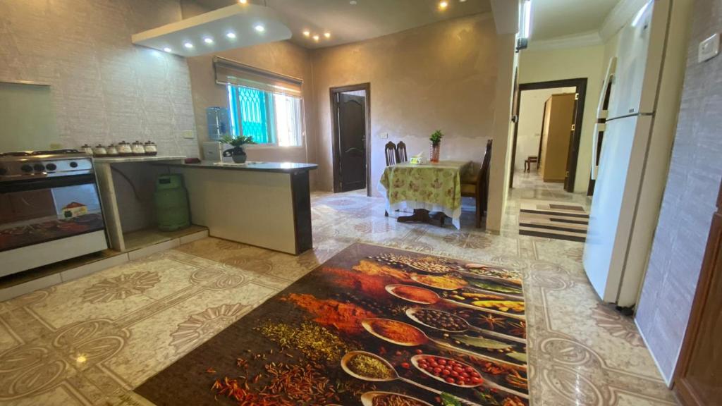 cocina con encimera y mesa con platos en el suelo en فيلا في الطبيعة في عجلون en Ajloun