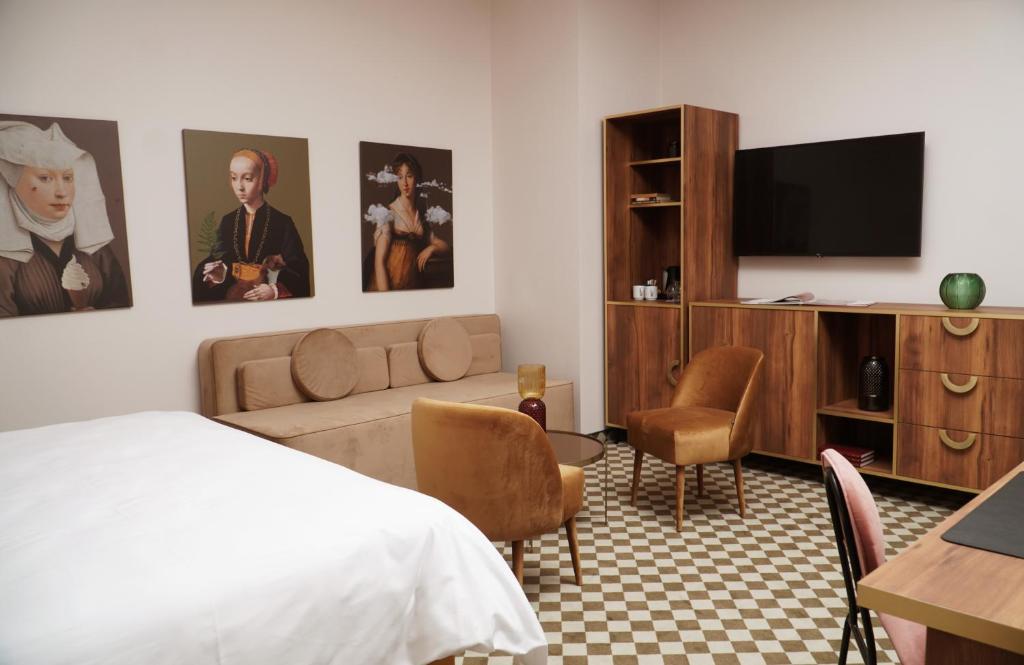 a hotel room with a bed and a flat screen tv at Hotel Pietryna in Łódź