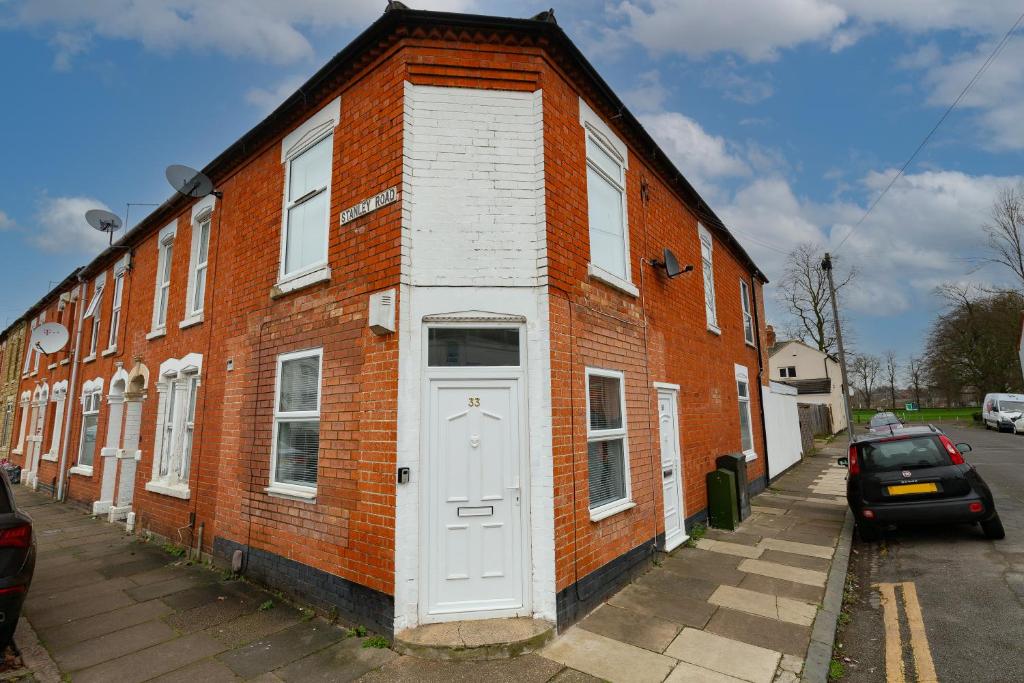 a red brick building with a white door at 33 Stanley Road in Northampton