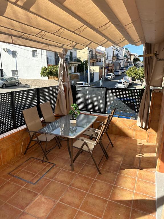 eine Terrasse mit einem Tisch und Stühlen auf dem Balkon in der Unterkunft Pisito de la Lola Flores in Santiponce