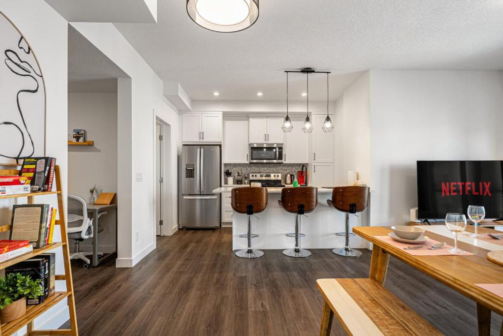 uma cozinha e sala de estar com mesa e cadeiras em Luxurious Townhome with King Bed and Garage Parking em Calgary