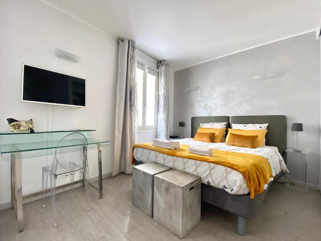 1 dormitorio con cama y escritorio de cristal en Elegant studio proche Palais des Festivals, en Cannes