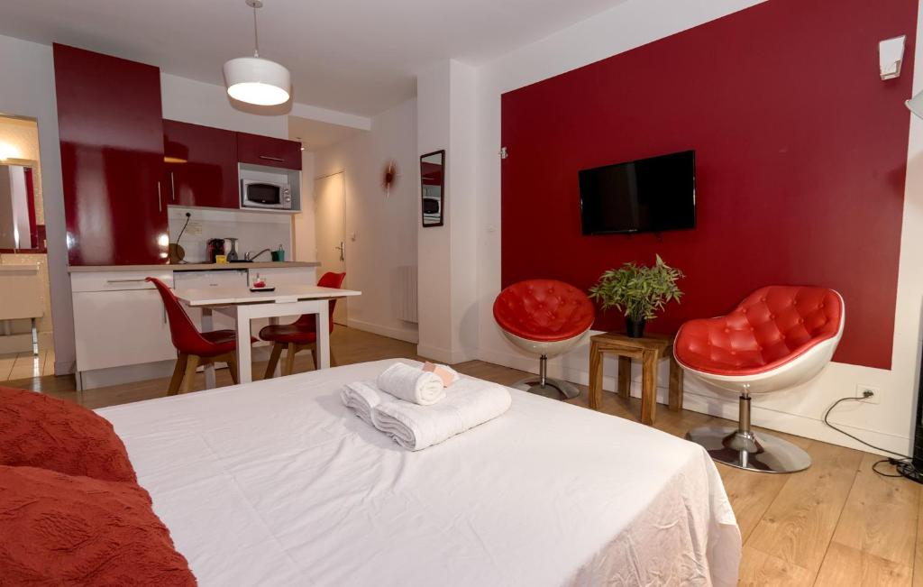 トゥールーズにあるStudio rouge Ramblas Centre Toulouseの赤い壁のベッドルーム(白いベッドと椅子付)