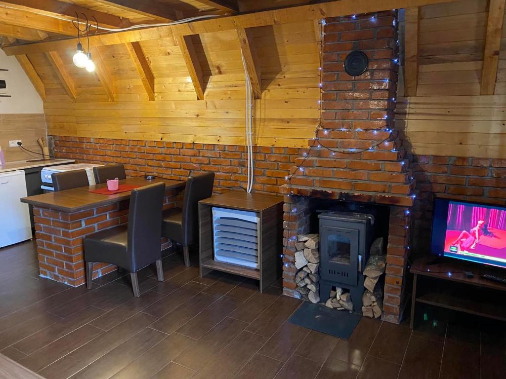 a room with a fireplace and a table and a television at STANET Forest Houses in Novoberdo