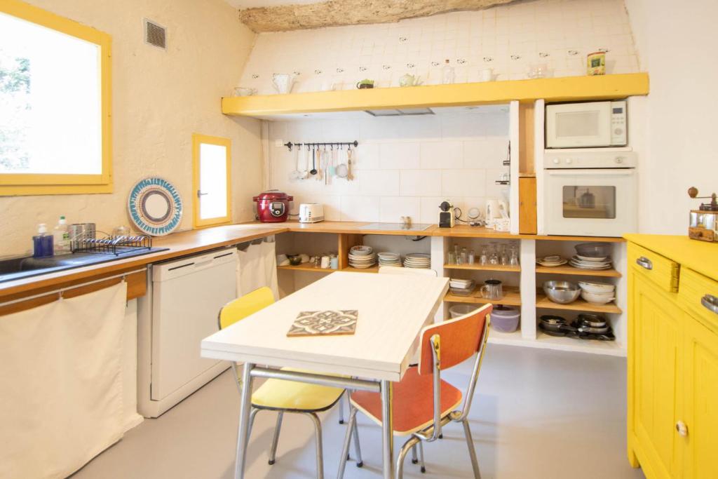 cocina con mesa blanca y sillas en Appartement Les Cyprès de l’Île, en Aviñón