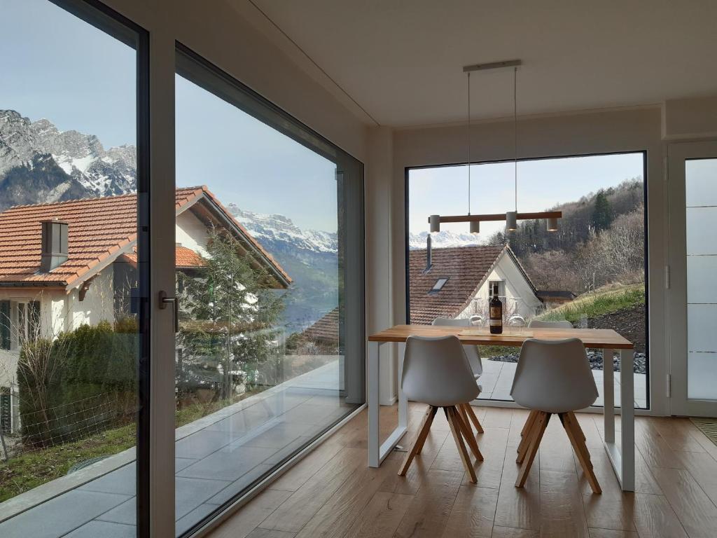 ein Esszimmer mit Bergblick in der Unterkunft Apartment Panorama am Walensee in Neubau-Villa in Obstalden