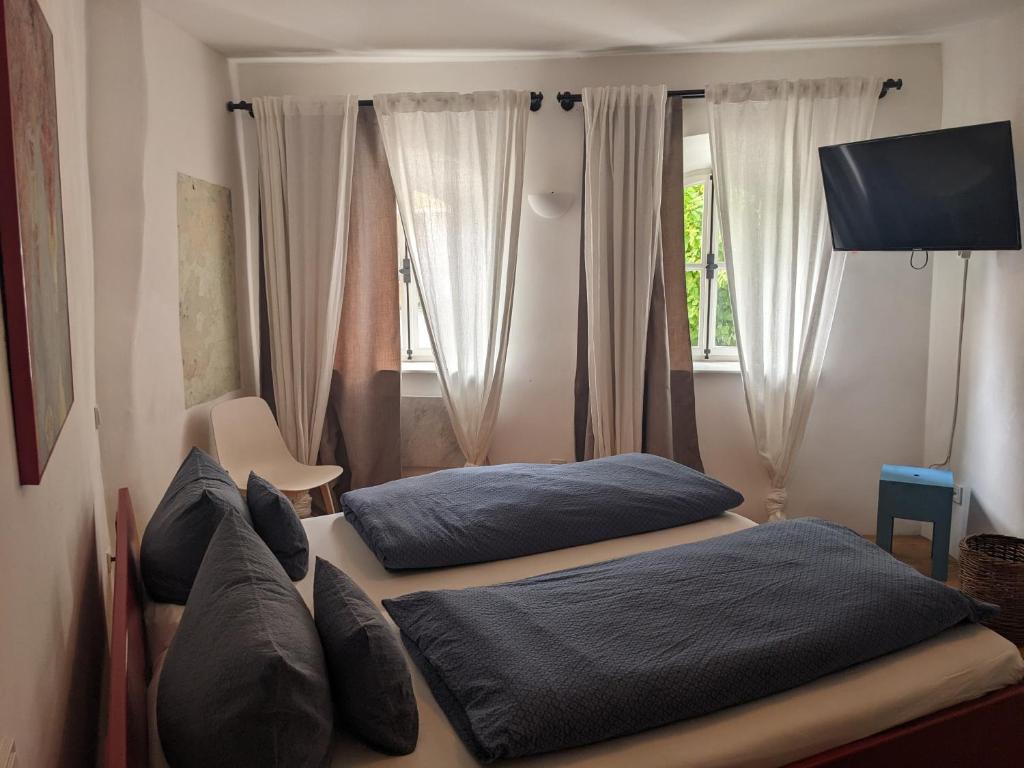 2 camas en un dormitorio con ventana en Ferienwohnung im historischen Ortskern von Kallmünz, en Kallmünz
