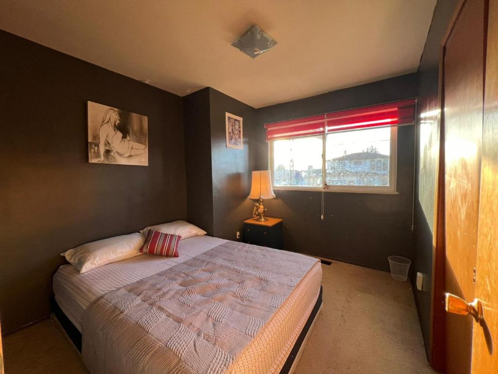 1 dormitorio con cama y ventana en Cozy Artistic Room Available in Delta Surrey Best Price en Delta