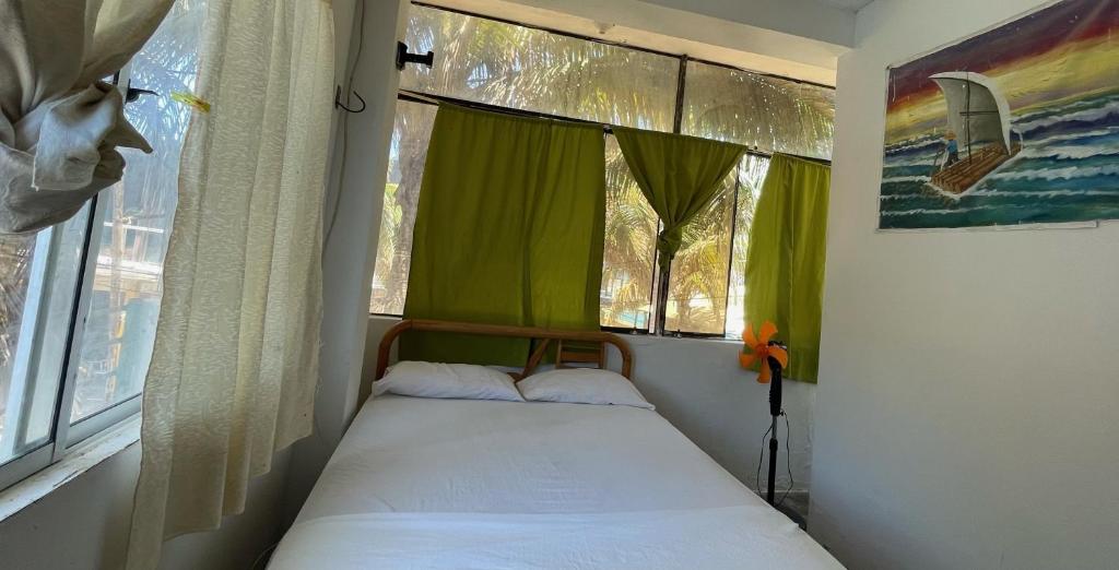 ein kleines Bett in einem Zimmer mit Fenster in der Unterkunft ANGELES DEL MAR in Máncora