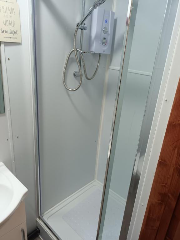 a shower with a glass door in a bathroom at 188 marsh road in Luton